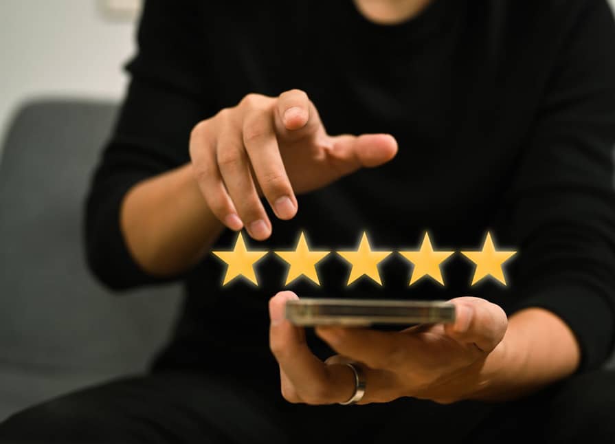 Un homme tenant un smartphone avec cinq étoiles dessus