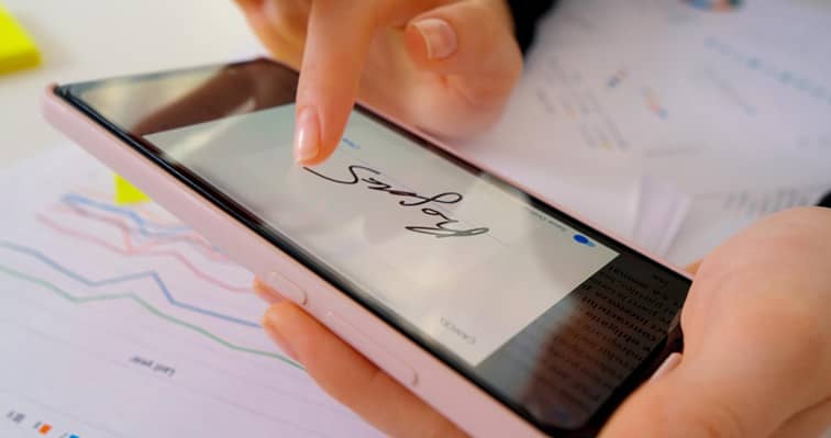 La main d'une femme écrit sur l'écran d'un smartphone